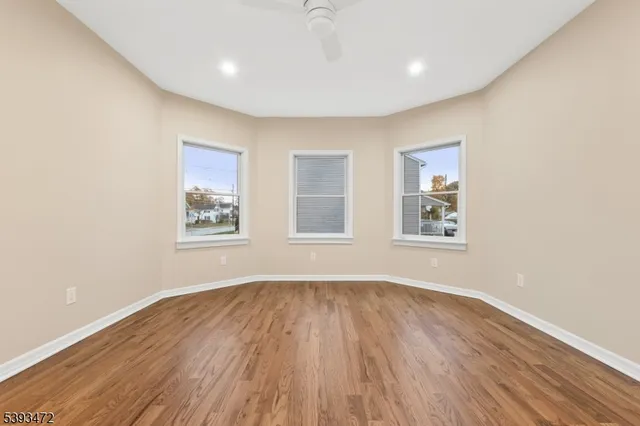 a big room with wooden floor and windows