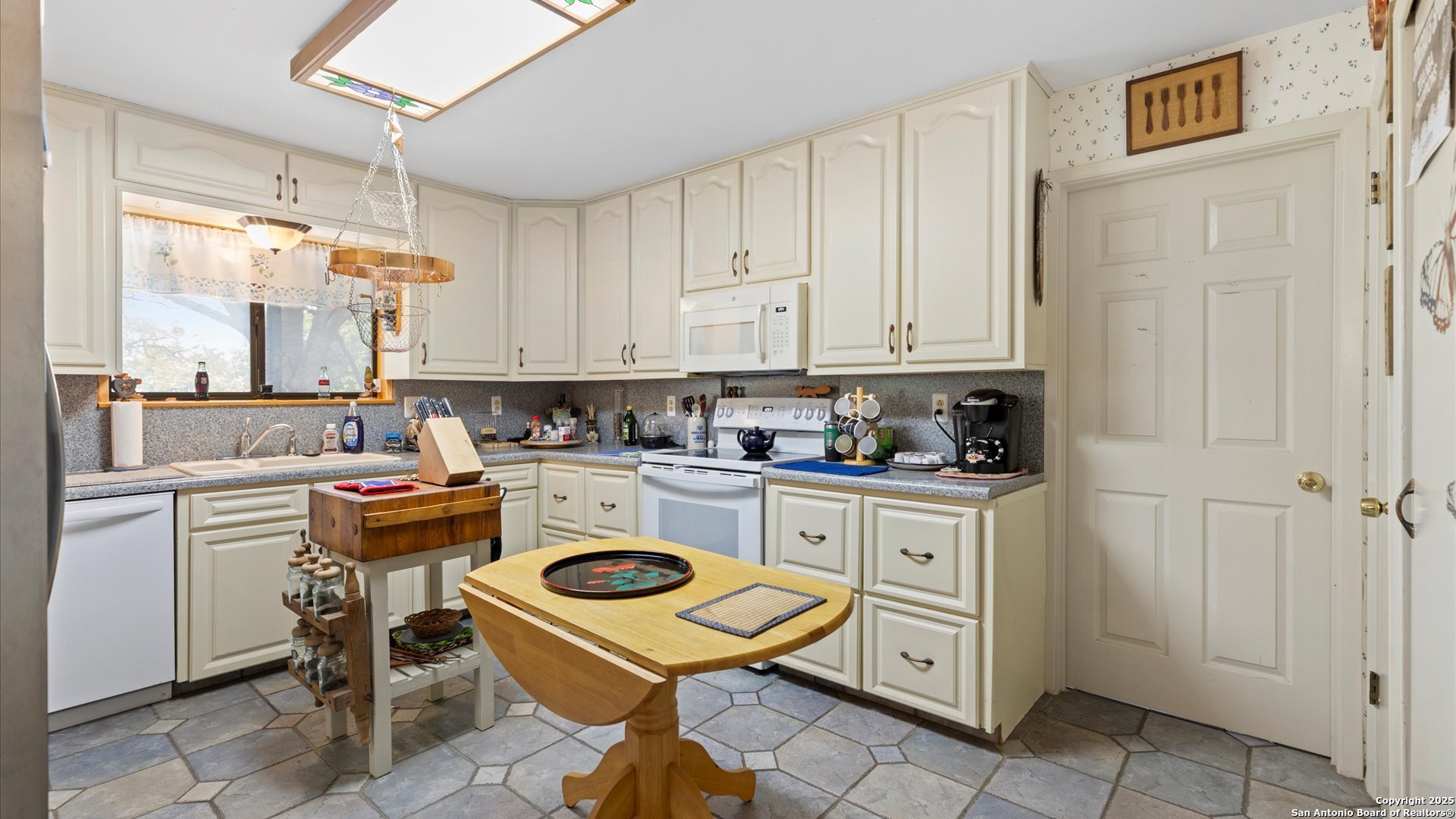 949 Burges Street Seguin, TX 78155 - Photo 9 of 26 a kitchen with a refrigerator a stove and white cabinets with wooden floor
