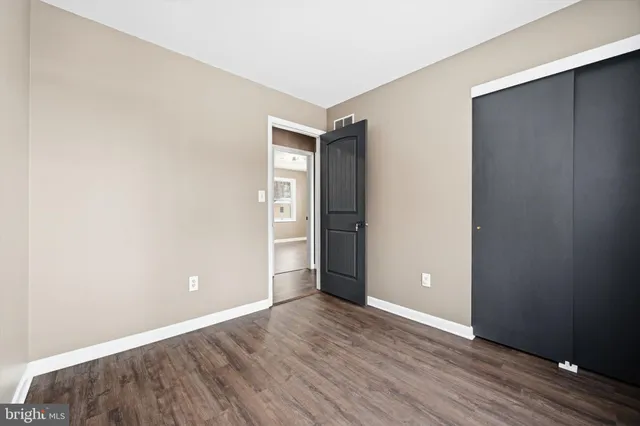 an empty room with wooden floor and closet