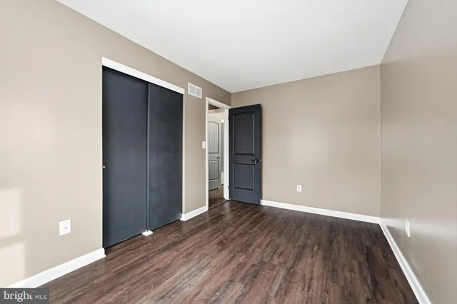 an empty room with wooden floor and closet