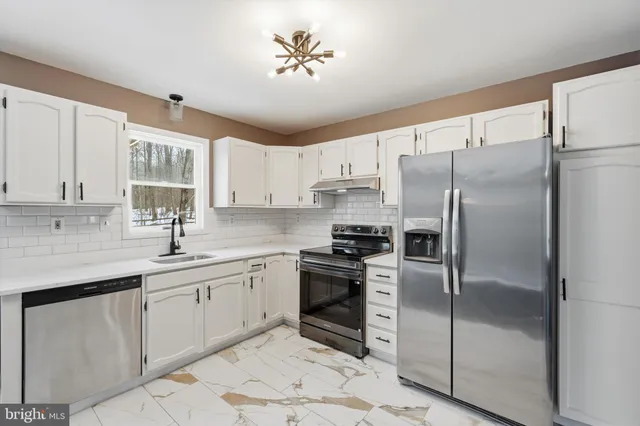 a kitchen with a refrigerator sink and cabinets