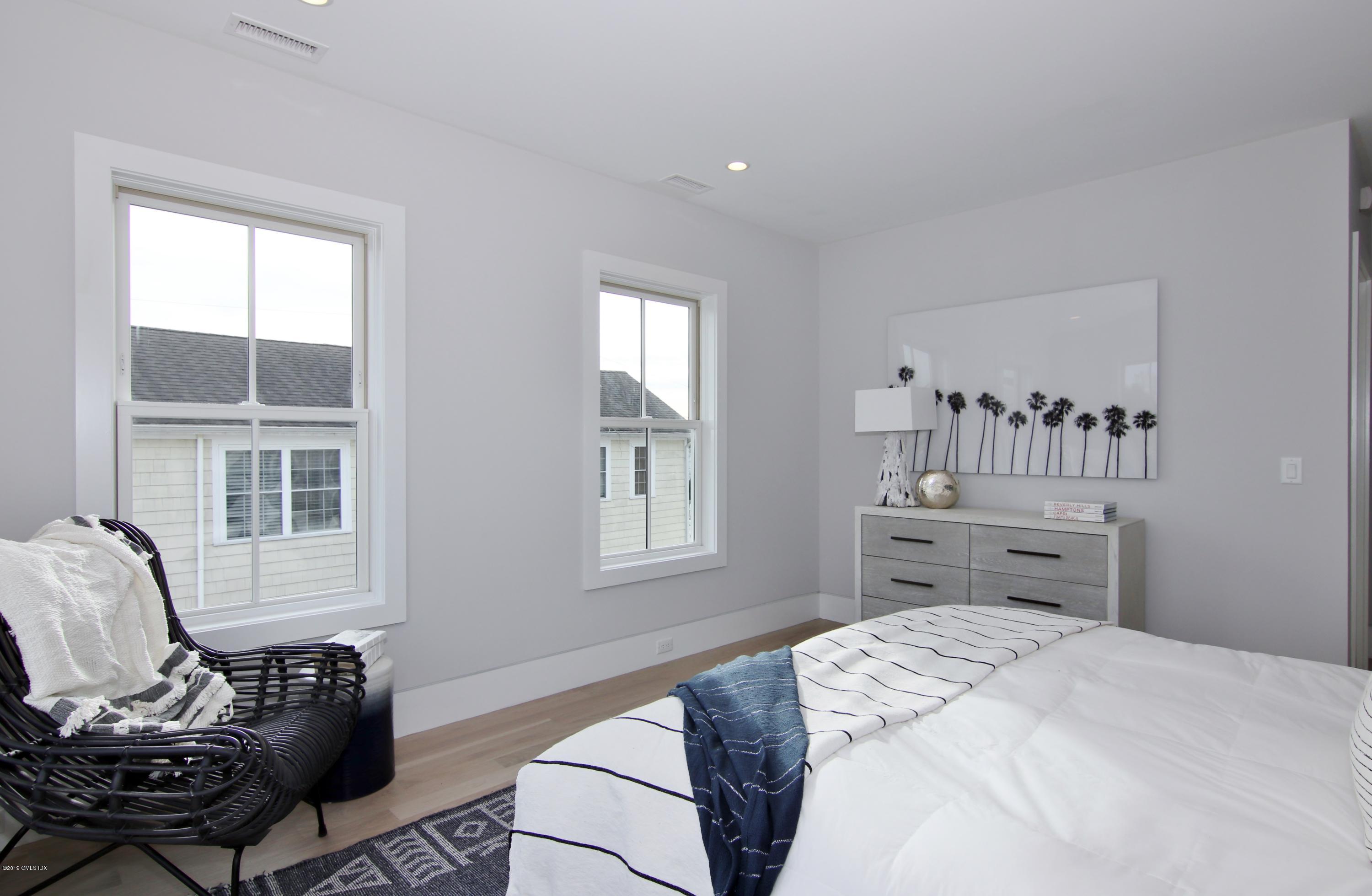 38 St Roch Avenue, Unit B Greenwich, CT 06830 - Photo 14 of 38 a bedroom with a bed and wooden floor