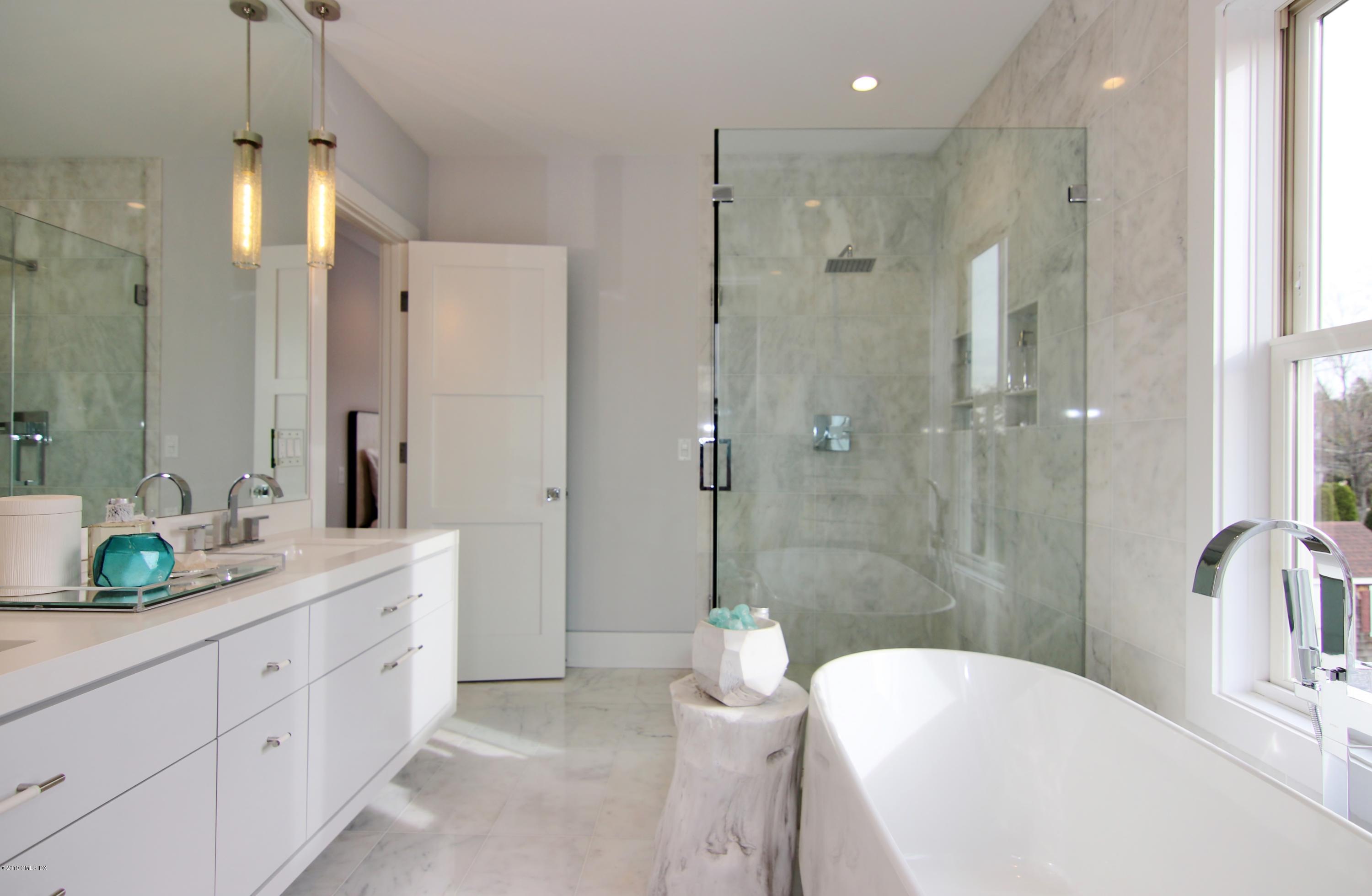 38 St Roch Avenue, Unit B Greenwich, CT 06830 - Photo 17 of 38 a spacious bathroom with a double vanity sink toilet mirror and bathtub