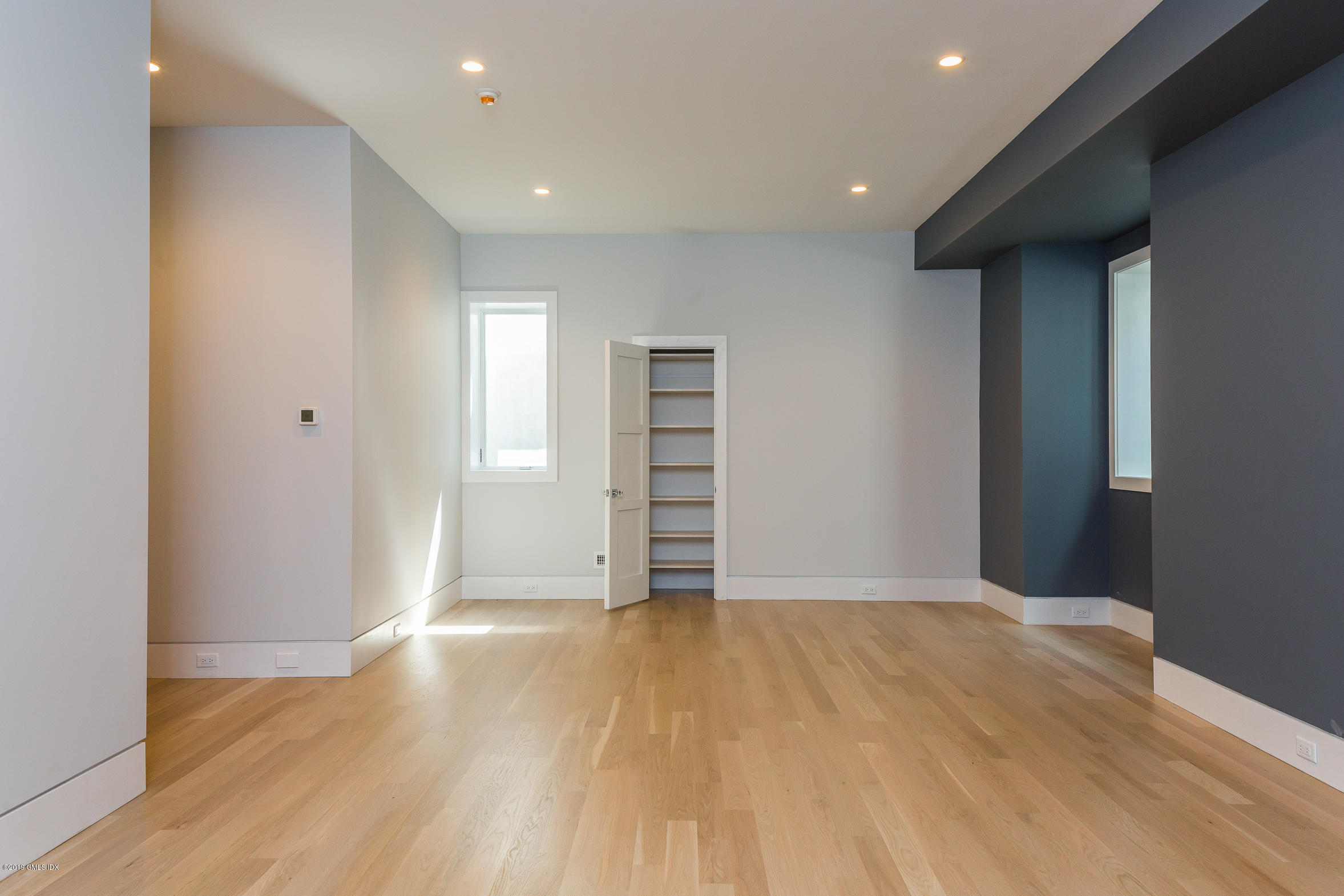 38 St Roch Avenue, Unit B Greenwich, CT 06830 - Photo 27 of 38 a view of an empty room with wooden floor and closet