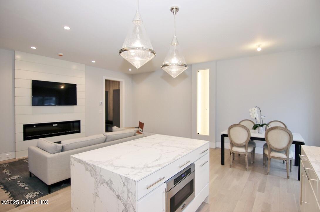 38 St Roch Avenue, Unit B Greenwich, CT 06830 - Photo 6 of 38 a kitchen with a sink and a stove top oven with wooden floor