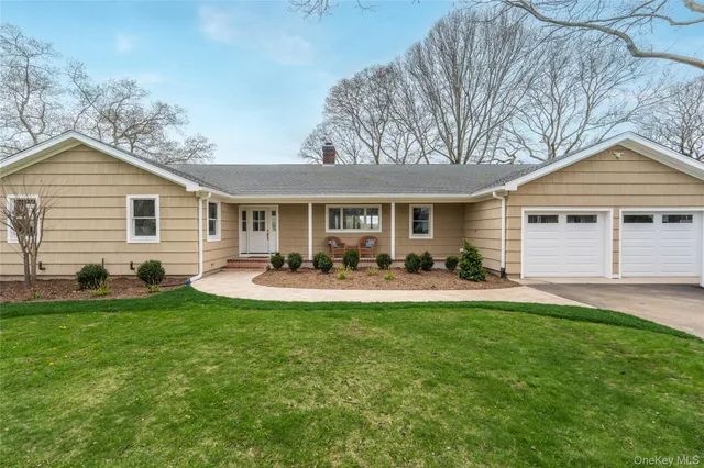 a view of a house with a yard and chairs