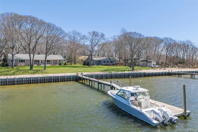 a view of a lake with a yard and large trees