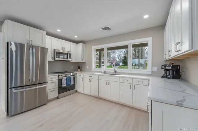 a kitchen with granite countertop stainless steel appliances a refrigerator sink and microwave