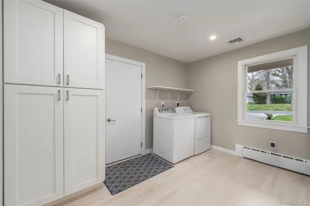 a utility room with cabinets washer and dryer