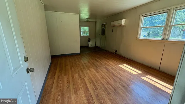 a view of a room with wooden floor and a window