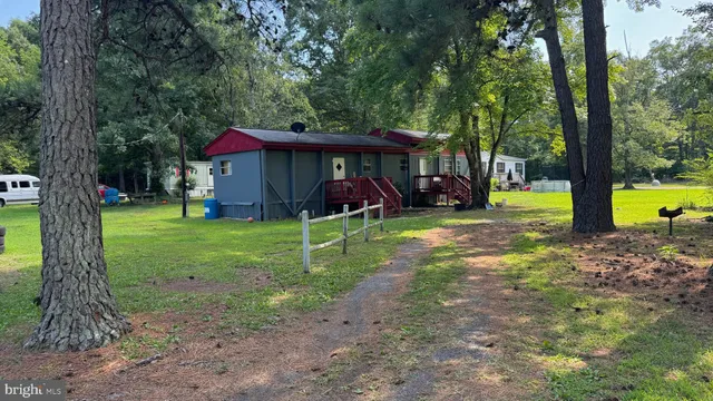 a view of a yard in front of a house with a large tree