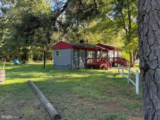 a view of a house with a yard and tree s