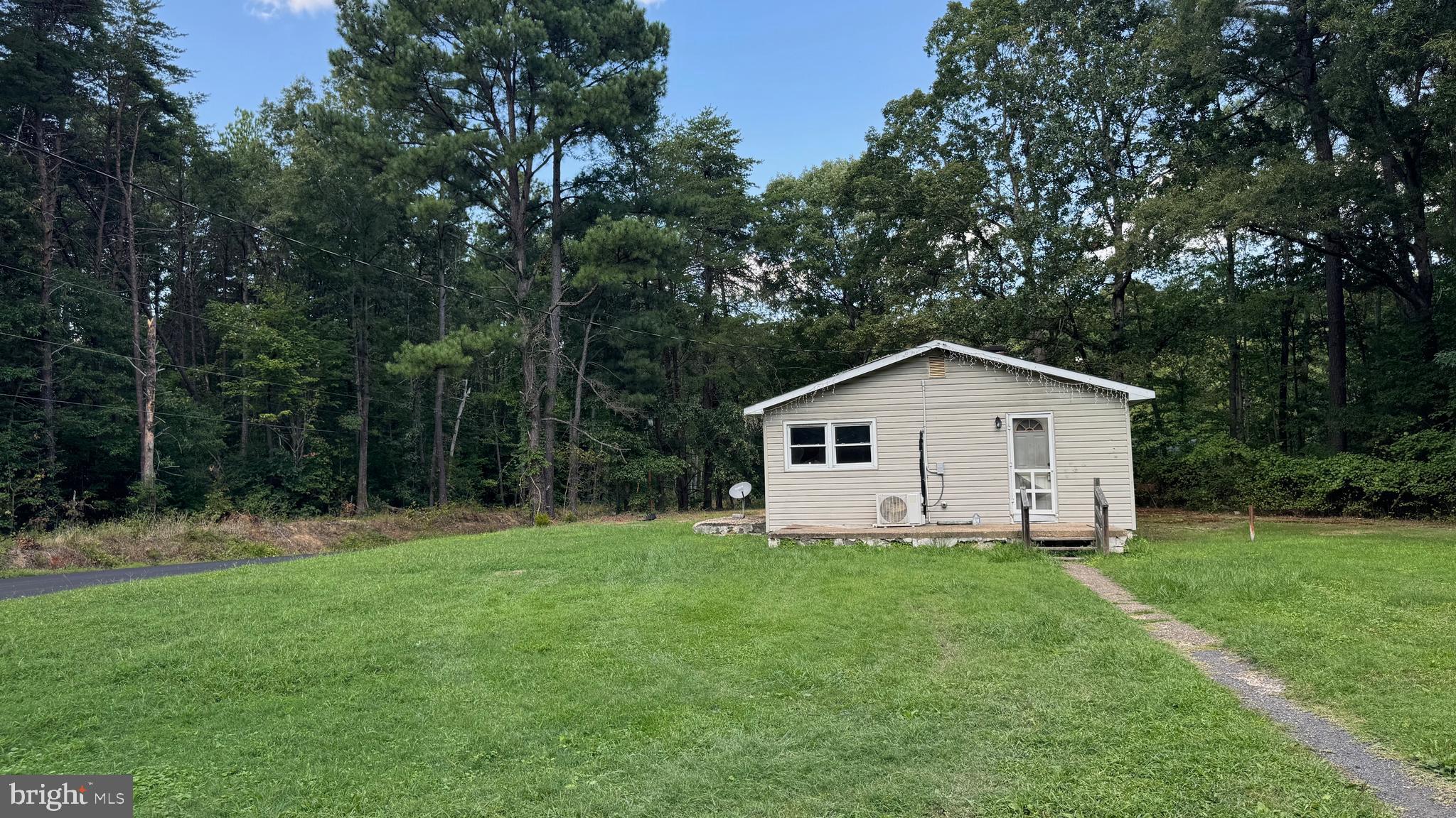 14405 Millbank Road King George, VA 22485 - Photo 6 of 20 a house that is sitting in the grass with large trees and plants