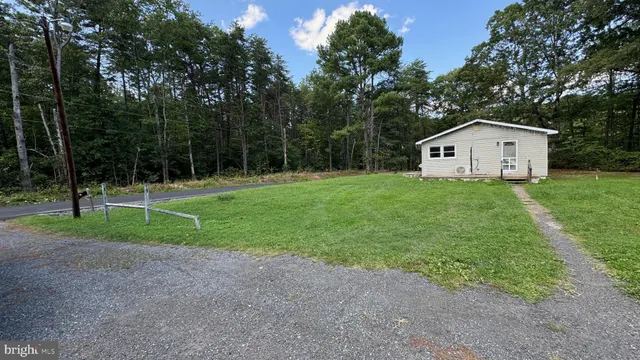 a view of a house with backyard and trees