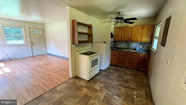 a kitchen with granite countertop a stove a sink and a refrigerator