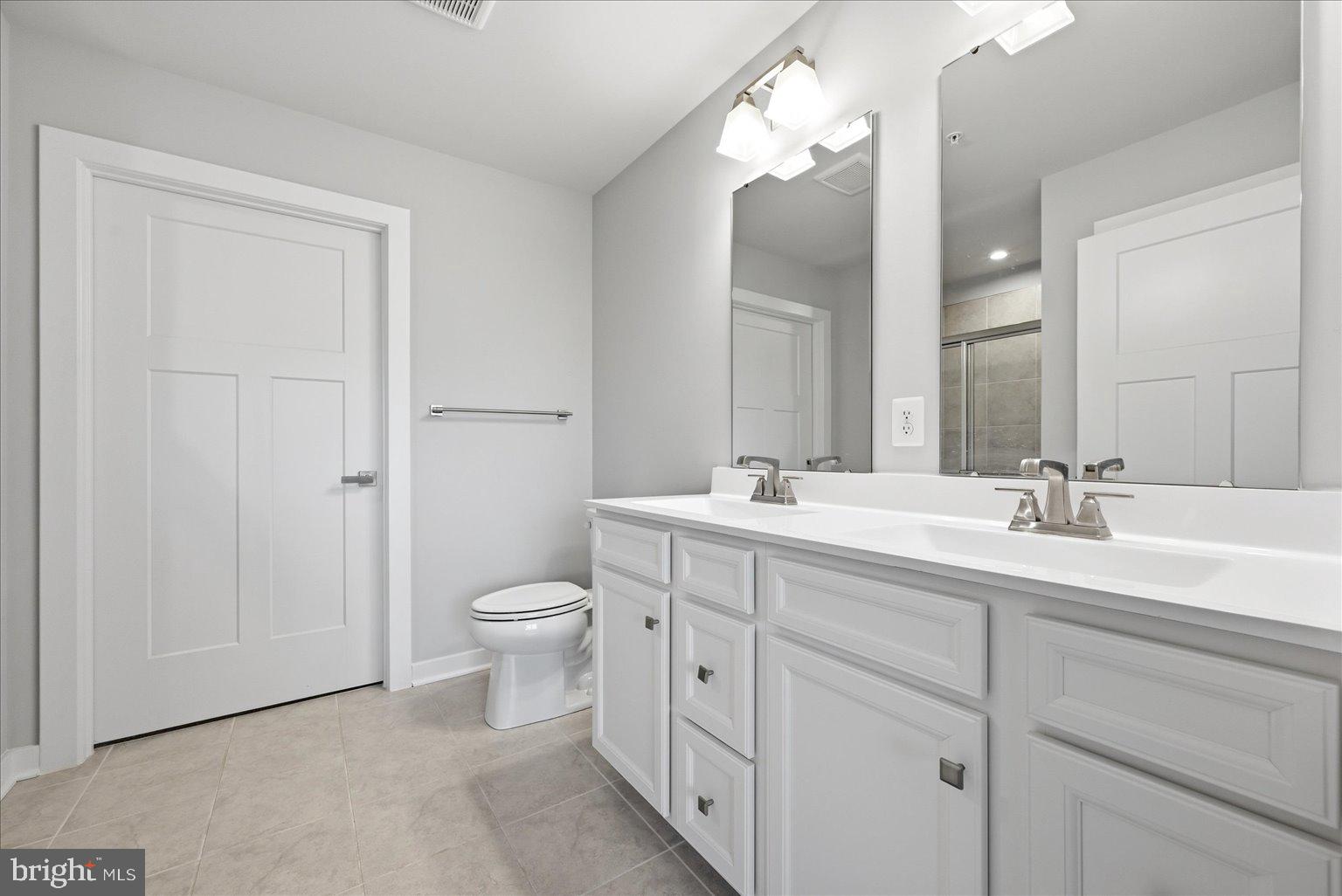 14380 Longhouse Loop Brandywine, MD 20613 - Photo 8 of 20 a bathroom with a double vanity sink a toilet and a mirror