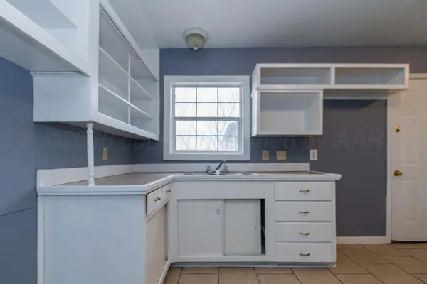 a kitchen with cabinets appliances a sink and a window