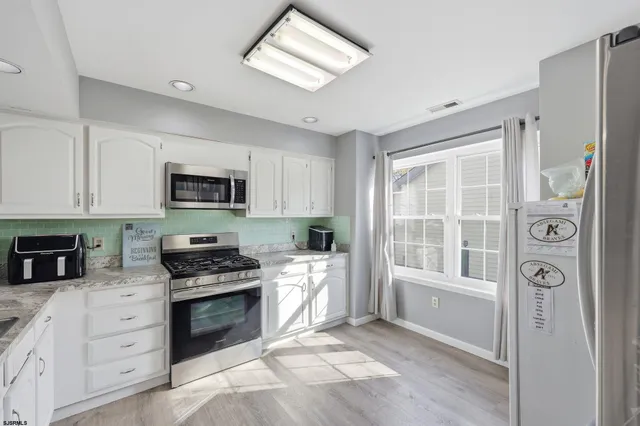 a kitchen with stainless steel appliances a stove a sink and a refrigerator