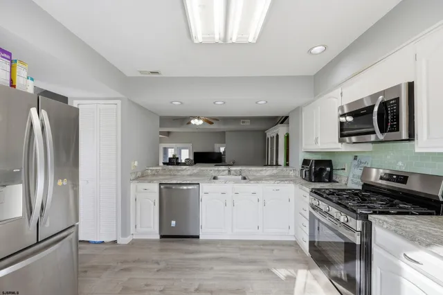 a kitchen with stainless steel appliances granite countertop a stove top oven a refrigerator a sink and dishwasher