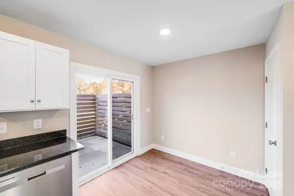 a kitchen with stainless steel appliances a stove top oven a refrigerator a sink and dishwasher with wooden floor