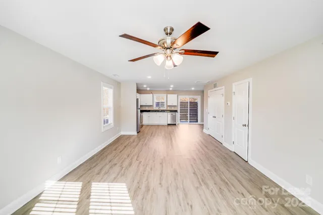a view of a room with wooden floor and a ceiling fan