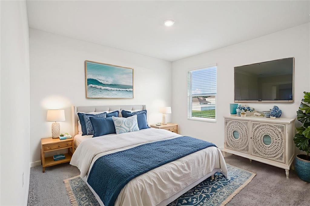 7067 Southeast 113th Place Belleview, FL 34420 - Photo 7 of 11 a bedroom with a bed and a flat tv screen on wall