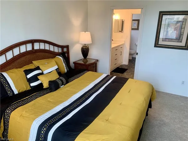 a bed room with a bed and a painting on the wall
