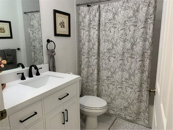 a bathroom with a sink a toilet and shower curtain