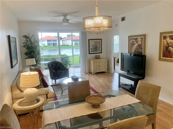 a living room with furniture a flat screen tv and a large window