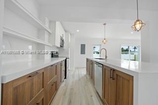 a kitchen with stainless steel appliances granite countertop a sink a stove top oven a counter space and cabinets