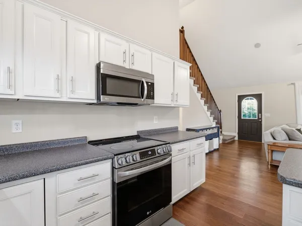 a kitchen with stainless steel appliances granite countertop a stove a microwave and a hard wood floors