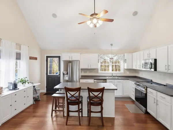 a kitchen with a stove a sink a dining table and chairs