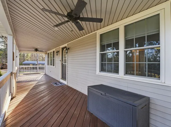 a view of a house with deck and furniture