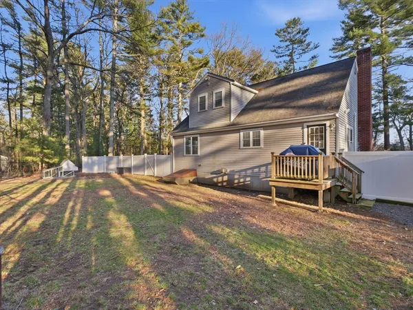 a view of a house with a big yard and large trees