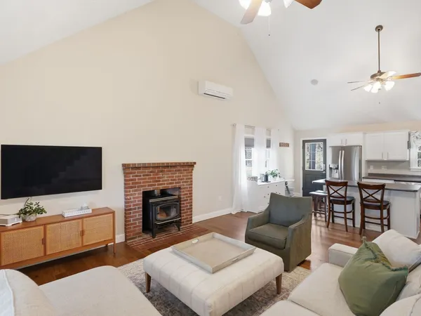 a living room with furniture a flat screen tv and a fireplace