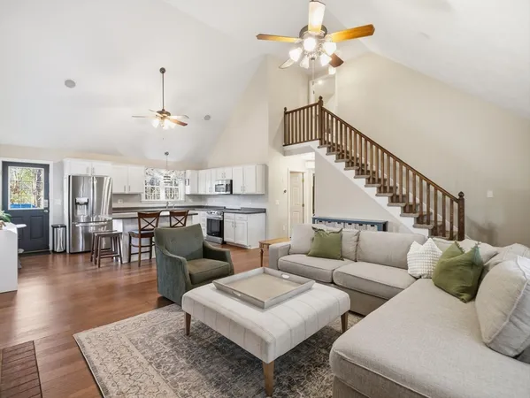 a living room with furniture and a view of kitchen
