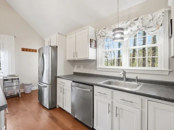 a kitchen with stainless steel appliances granite countertop a sink and a refrigerator