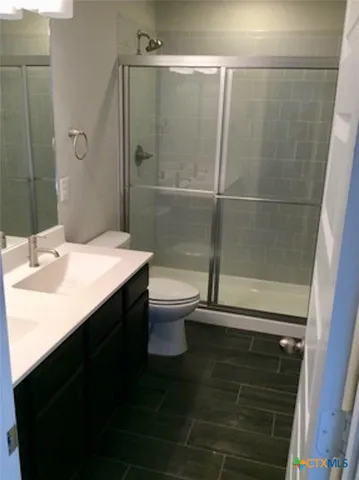 a bathroom with a sink a toilet a mirror and shower