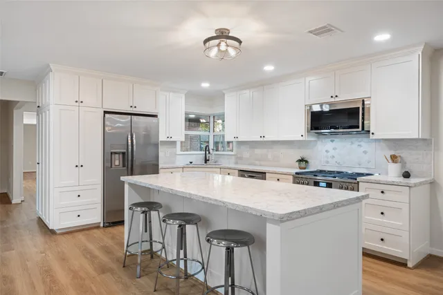 a kitchen with a white cabinets and stainless steel appliances