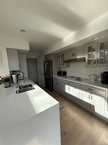 a kitchen with stainless steel appliances a sink dishwasher stove refrigerator and cabinets
