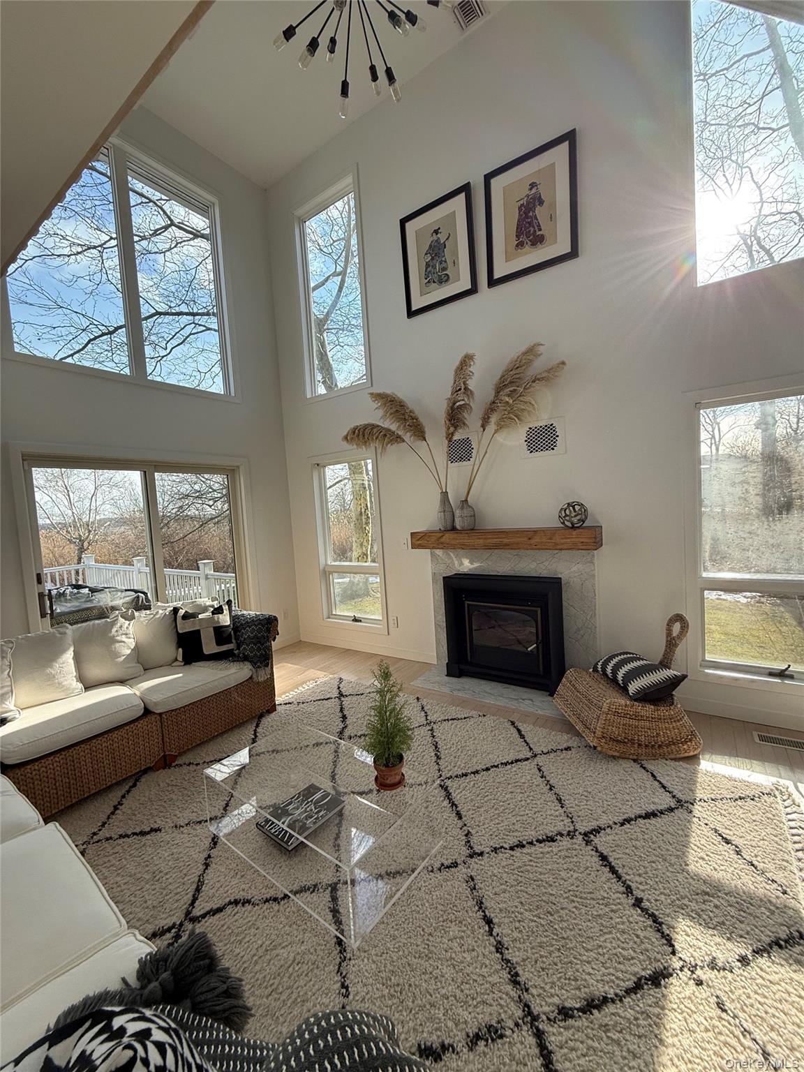 845 Budds Pond Road Southold, NY 11971 - Photo 7 of 9 a living room with furniture a large window and a fireplace