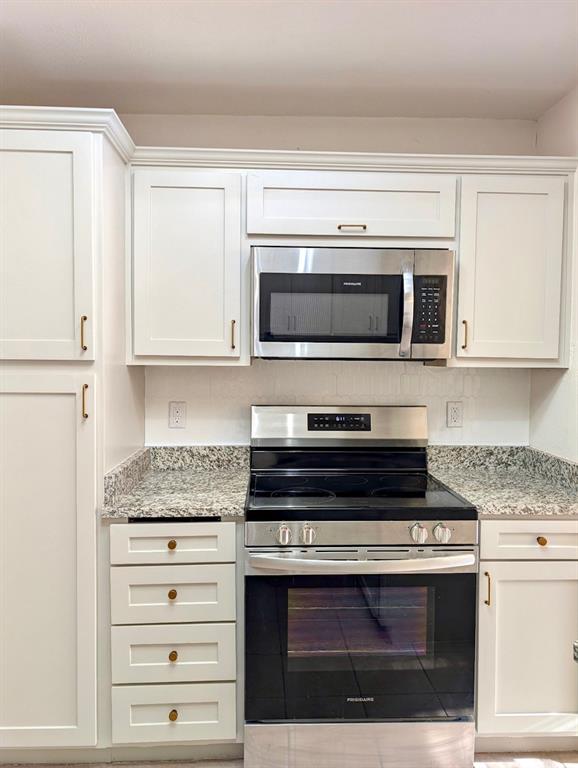 12680 Hillcrest Road, Unit 4101 Dallas, TX 75230 - Photo 13 of 37 Modern kitchen featuring white shaker-style cabinetry with gold-finish hardware, a stainless steel electric range, an over-the-range microwave, and light-toned speckled countertops