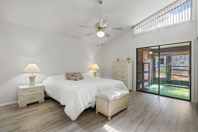 a bedroom with a bed lamp and a large window