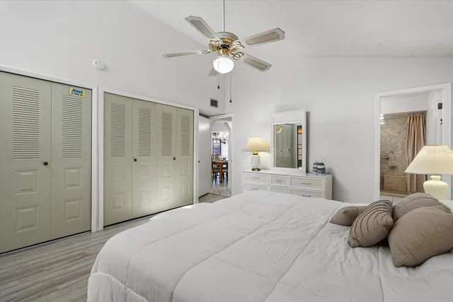 a bedroom with a large bed closet and chandelier