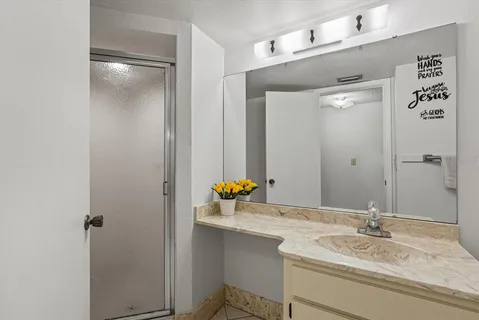 a bathroom with a granite countertop sink and a mirror
