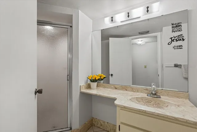 a bathroom with a granite countertop sink and a mirror
