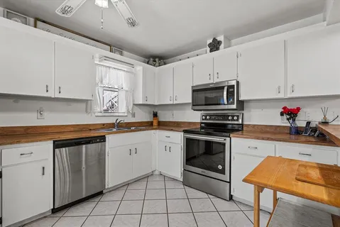 a kitchen with white cabinets appliances and a sink