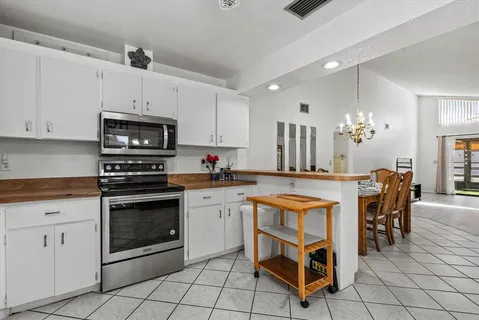 a kitchen with cabinets appliances and a dining table