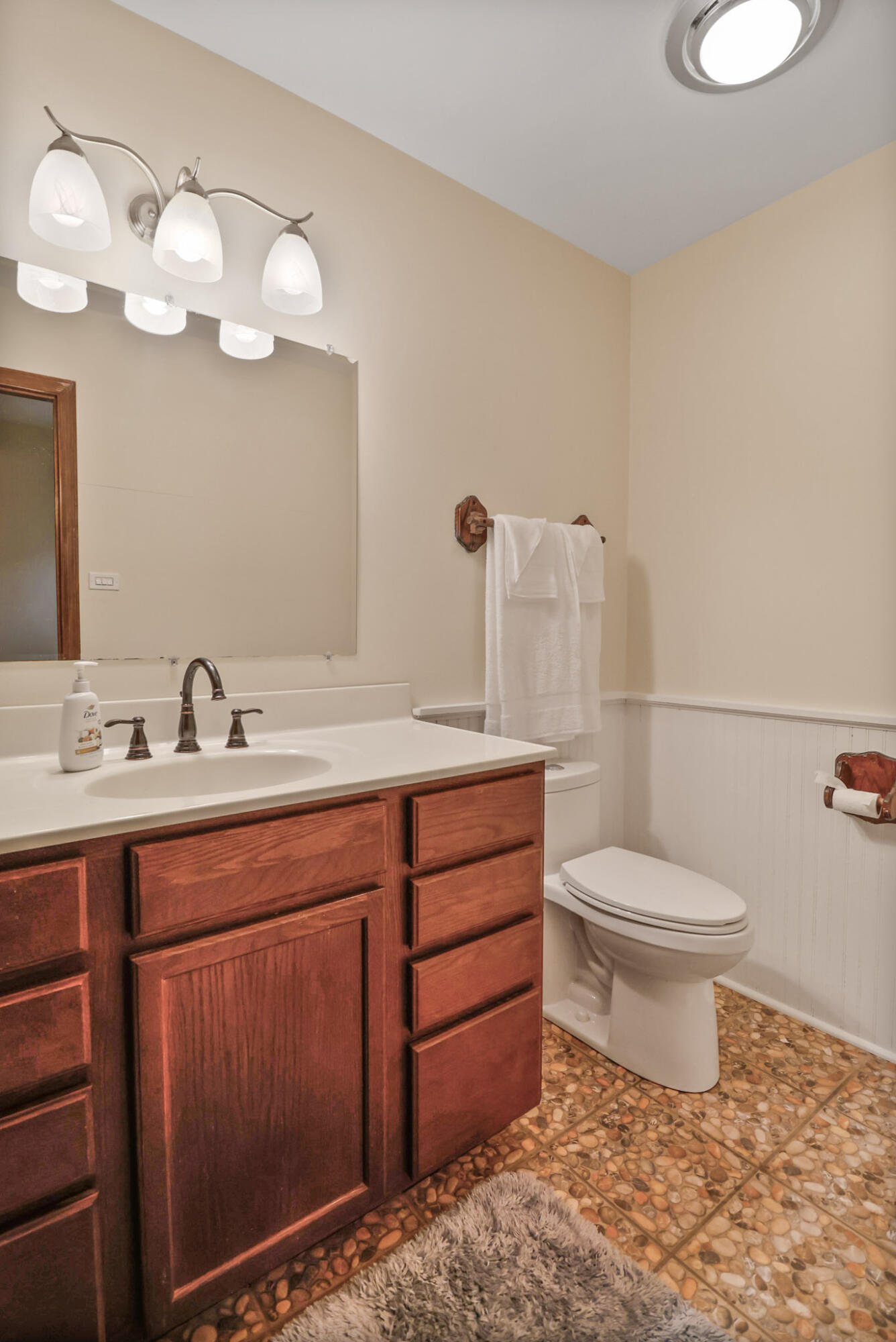 8670 Howard Street St. John, IN 46373 - Photo 24 of 34 a bathroom with a toilet a sink a mirror and vanity
