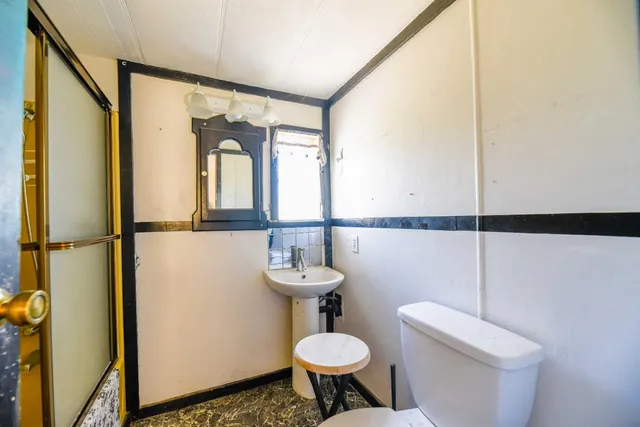 a bathroom with a sink toilet and a mirror